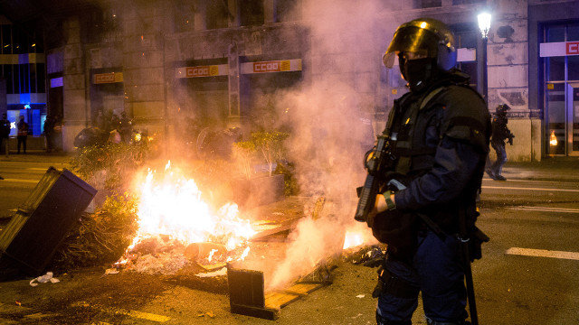 Agentes desplegados en la zona de los disturbios en Barcelona, donde se quemó mobiliario urbano. EFE