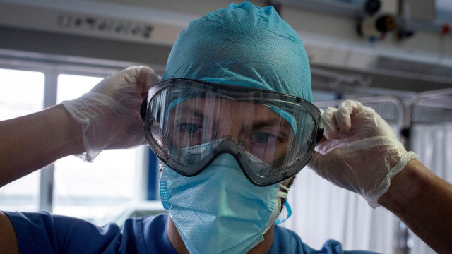 Un trabajador sanitario se coloca las gafas de protección en la Uci del Hospital Cosaga de Ourense. EFE