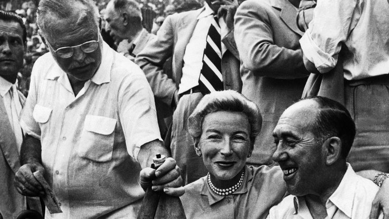 Ernest Hemingway (i) y su mujer, Mary Welsh (c), en la barrera de la plaza de toros durante una corrida de los Sanfermines. EFE