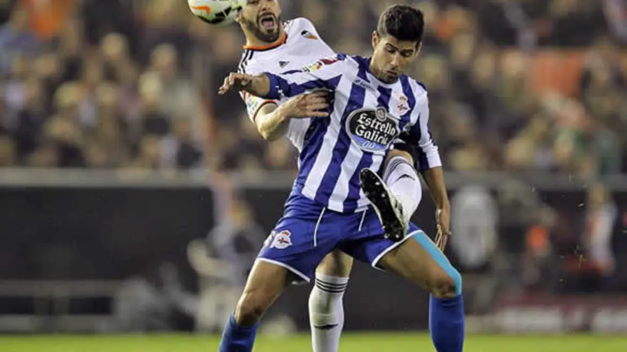 El lateral del jugador del Deportivo de La Coruña, Juanfran protege un balón ante Álvaro Negredo, del Valencia.