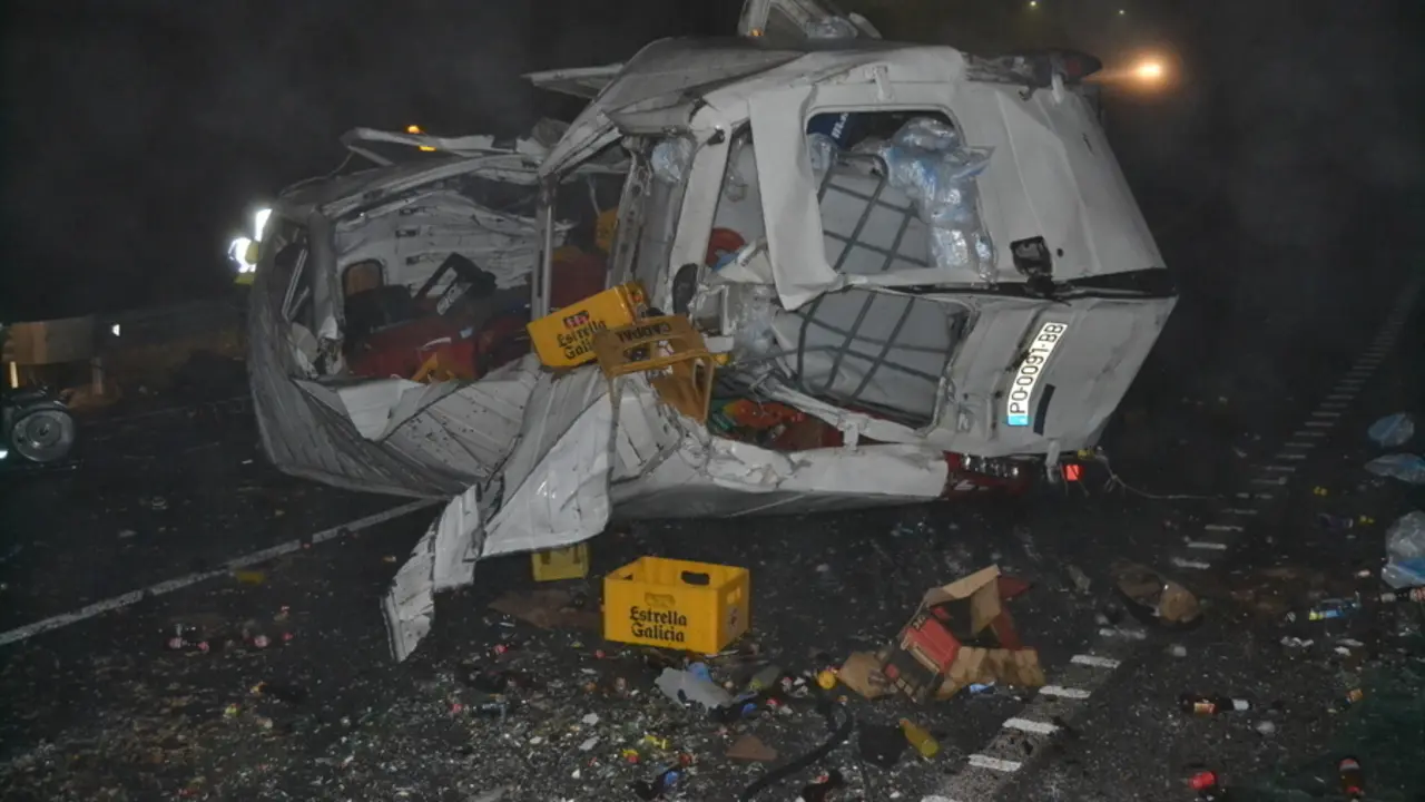 La furgoneta volcada y su carga esparcida sobre la calzada