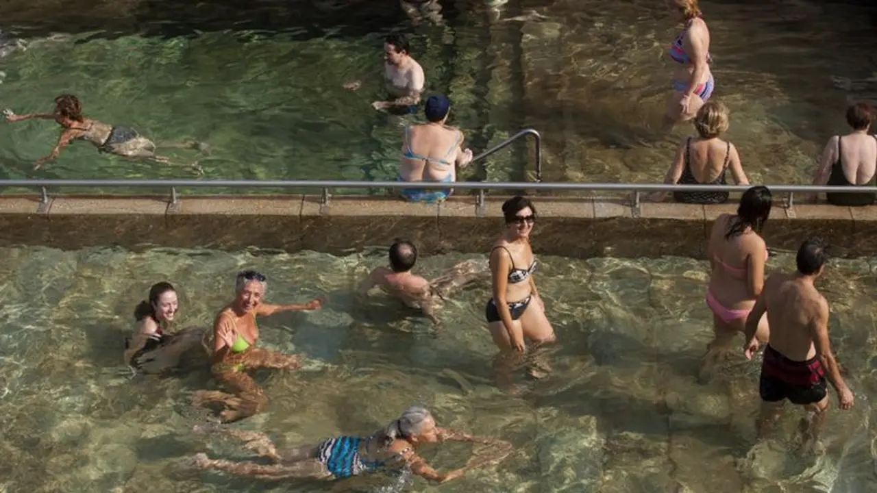 Varias personas combaten el calor en la piscina termal de As Burgas, en Ourense