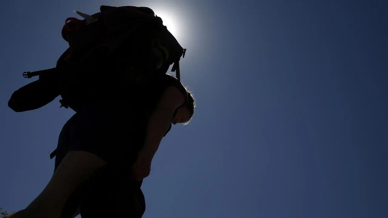 Una peregrina camina bajo el sol