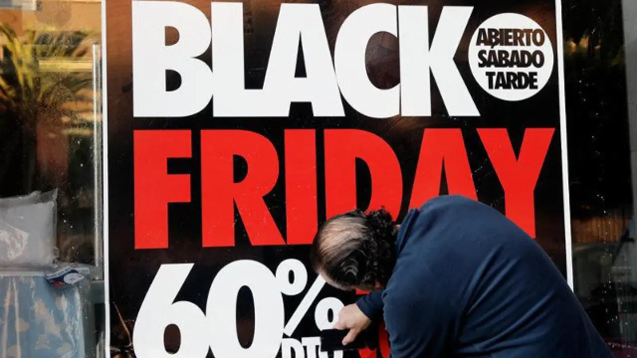 Un hombre coloca un cartel del Black Friday. JUAN CARLOS CÁRDENAS (EFE)