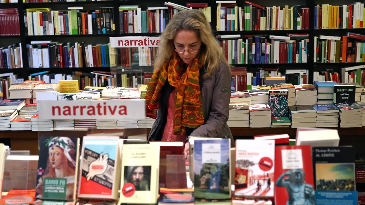 Una mujer consulta varios ejemplares en una librería. AEP