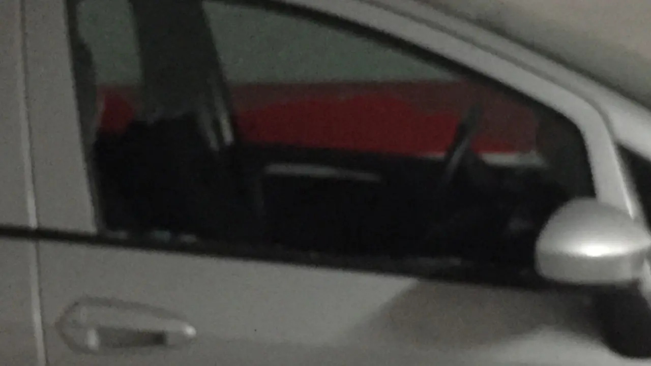 Luna rota en uno de los coches asaltados en Santiago. J.M.