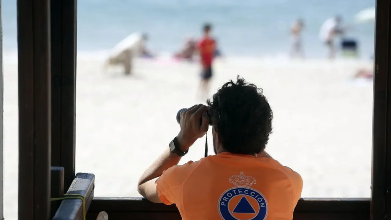Un socorrista pendiente de los bañistas en una playa. AEP