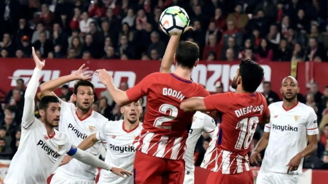 Varios jugadores del Sevilla piden mano del Atlético de Madrid. RAÚL CARO (EFE)