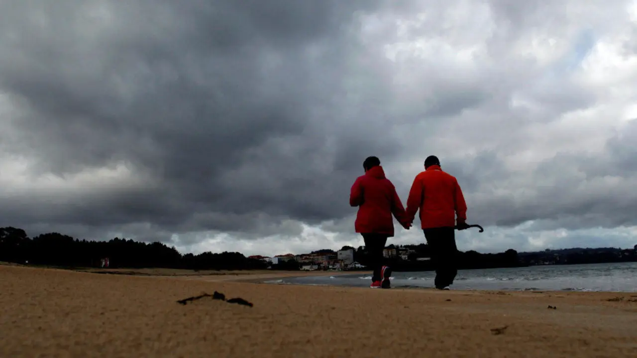 Una pareja pasea por la playa en Miño