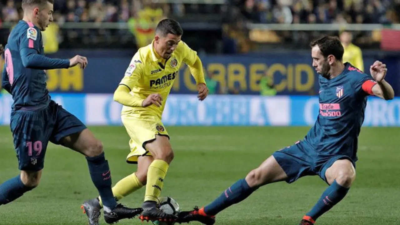 Lucas Hernández y Diego Godín disputan el balón a Pablo Fornals. MANUEL BRUQUE (EFE)