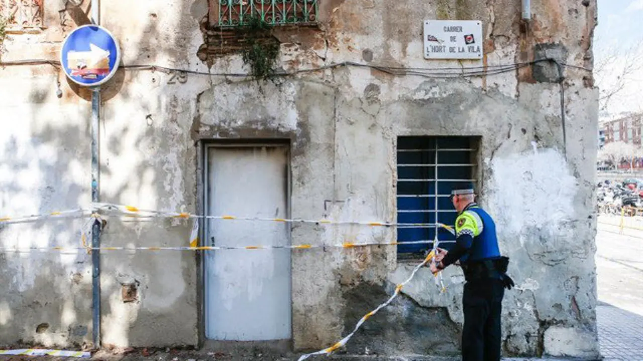Un agente de la Guardia Urbana inspecciona el edificio tras el incendio. ENRIC FONTCUBERTA (EFE)