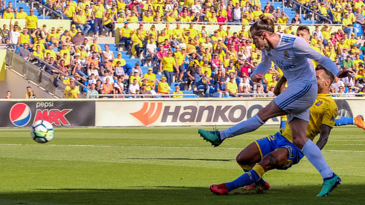 Gareth Bale realiza un disparo ante la presencia de Míchel Macedo. ÁNGEL MEDINA G. (EFE)