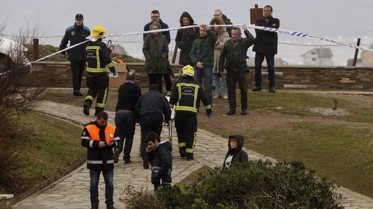 El alcalde de Ribadeo y el delegado de la Xunta levantan la cinta de seguridad para que pase la camilla con la víctima mortal. JOSÉ Mª ALVEZ