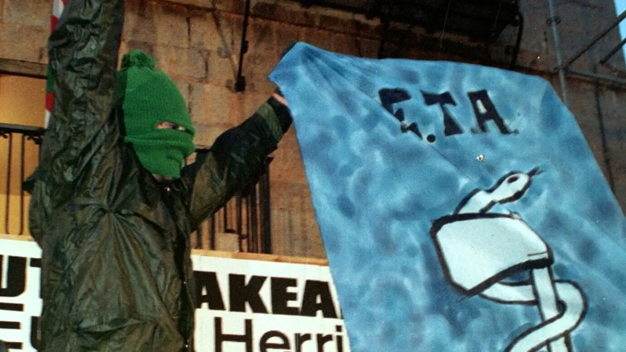 Un encapuchado muestra una pancarta de Eta.AEP