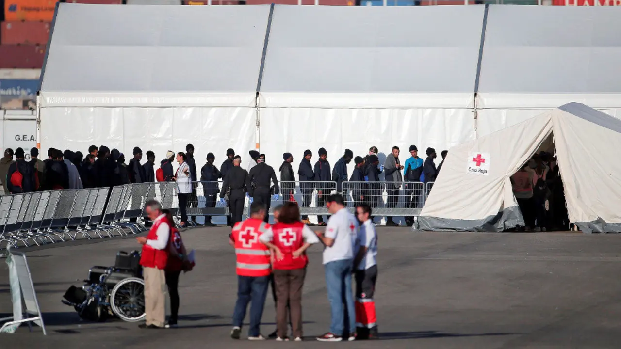 Imagen de los primeros inmigrantes atendidos en el puerto valenciano. MANUEL BRUQUE (EFE)