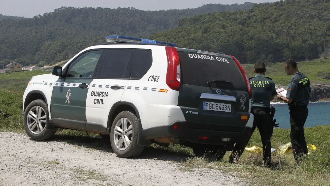 Dos agentes junto al cuerpo del pescador en Xove. JOSÉ Mª ÁLVEZ