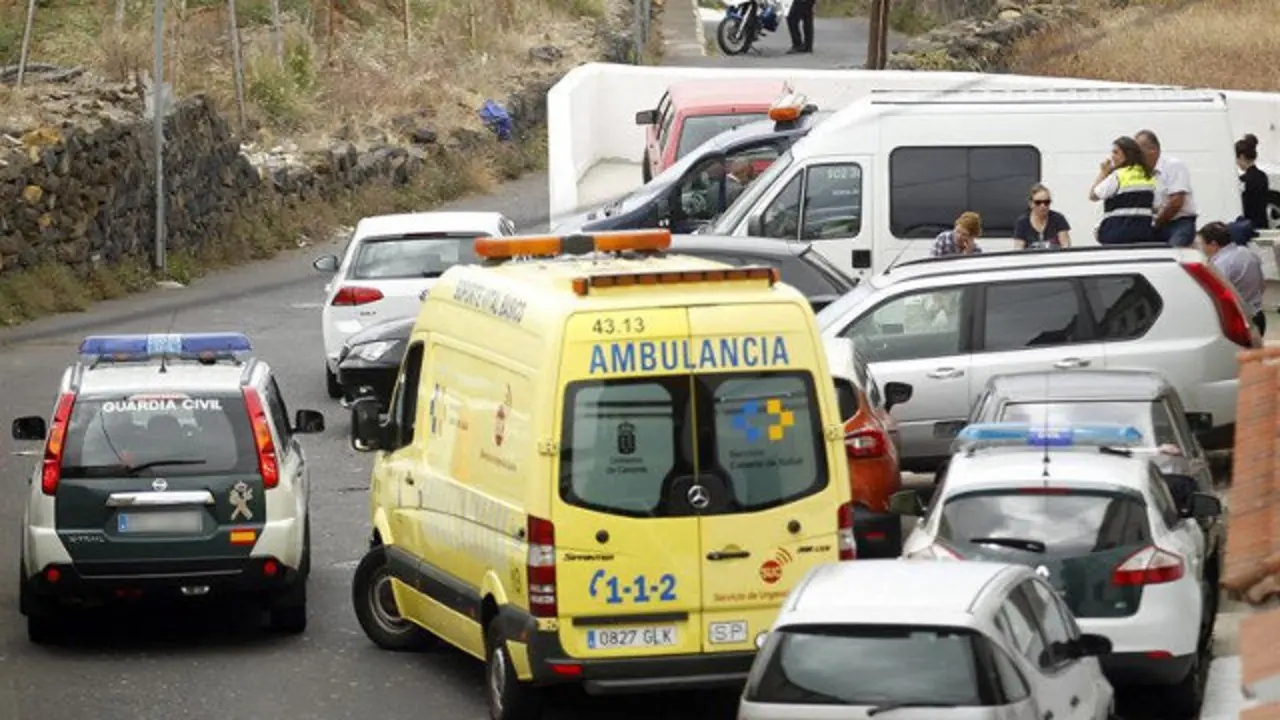 Agentes de la Policía Judicial y de la Guardia Civil y efectivos sanitarios, ante la casa donde apareció muerta la familia. CRISTÓBAL GARCÍA