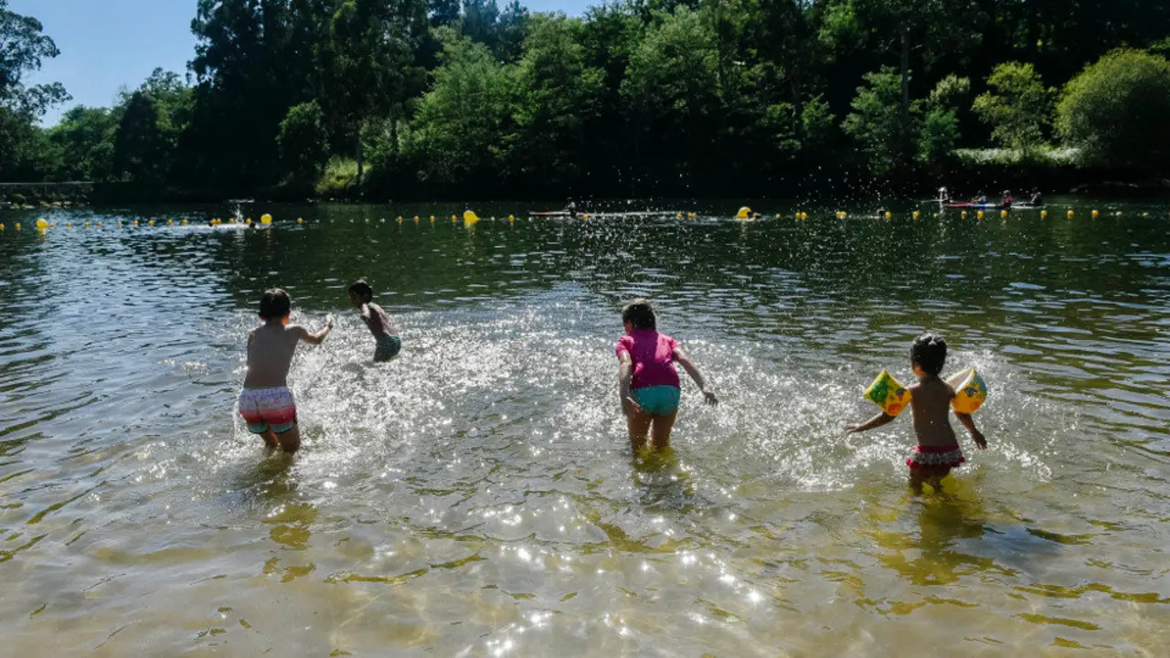 Un grupo de niños disfrutan de la playa fluvial del Lérez. ALBA SOTELO