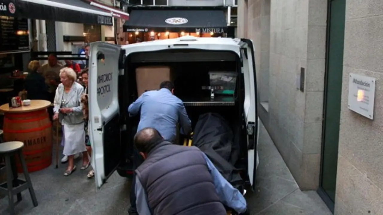 Los funerarios retiran el cuerpo de la mujer en la calle de la Estrella de A Coruña. CABALAR