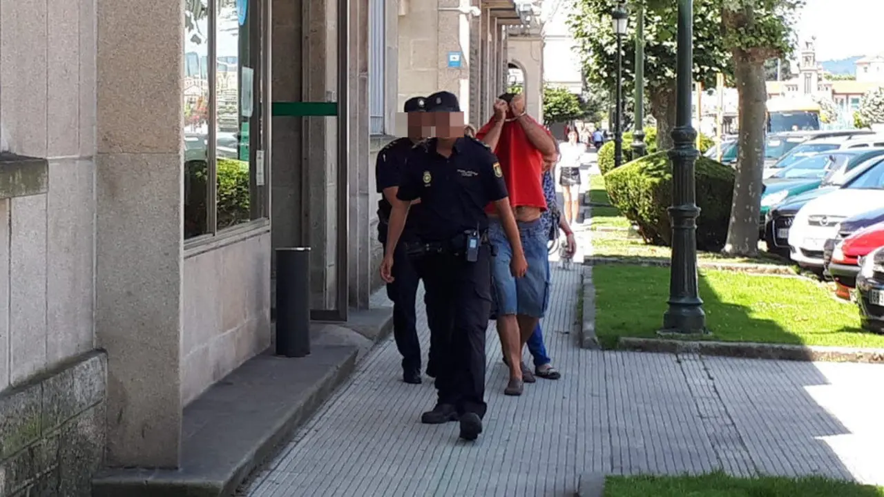 El acusado de acuchillar a su pareja en Mogor, custodiado por una pareja de agentes, en juzgados de Marín. CAROLINA NEIRA