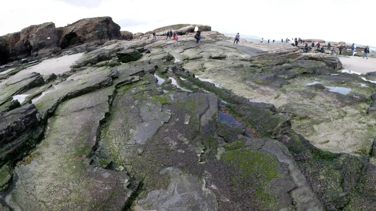 Gente pasea una playa. JOSÉ Mª ÁLVEZ