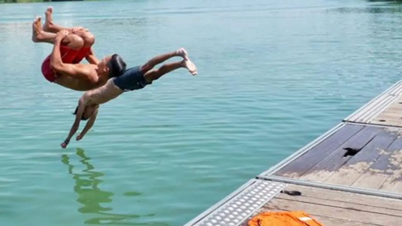 Unos niños se lanzan al agua. EFE