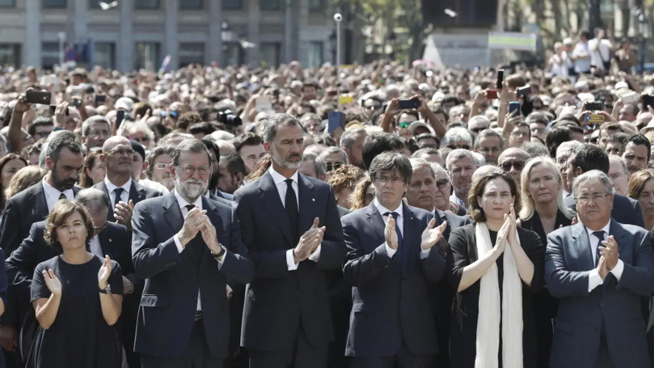 El rey Felipe VI, acompañado por el expresidente Mariano Rajoy, la exvicepresidenta del Gobierno Soraya Sáenz de Santamaría, el president Carles Puigdemont, la alcaldesa de Barcelona, Ada Colau y el exministro Juan Ignacio Zoido, durante un homenaje a las víctimas de los atentados, en 2017. ANDREU DALMAU (EFE)