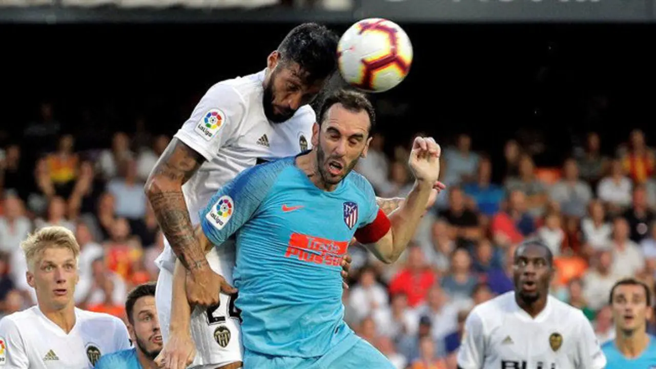 Godín cabecea un balón ante Garay. MANUEL BRUQUE (EFE)