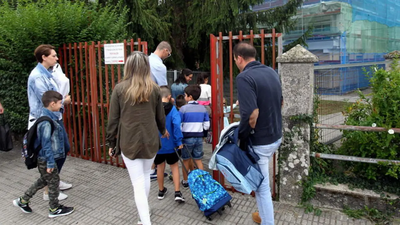 Padres y pequeños acceden a un colegio en obras de Outeiro de Rei en el primer día de clase. XESÚS PONTE