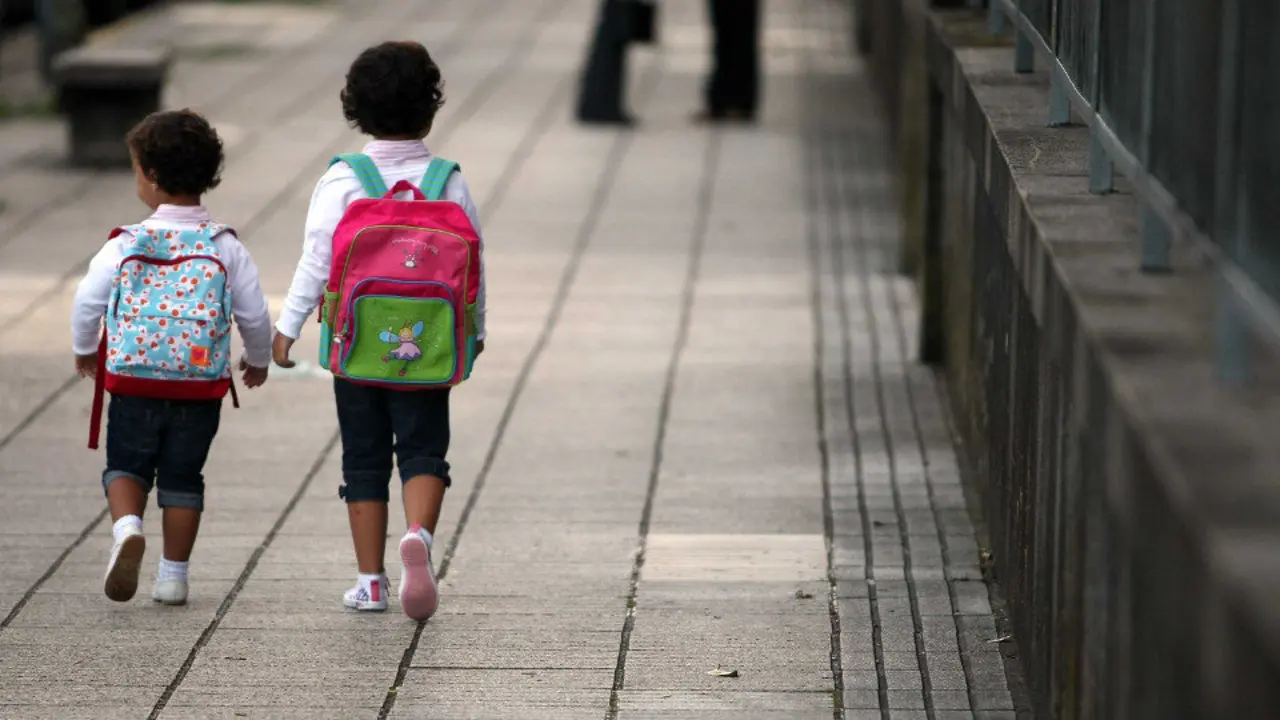 Dous nenos van camiño do seu colexio. ADP