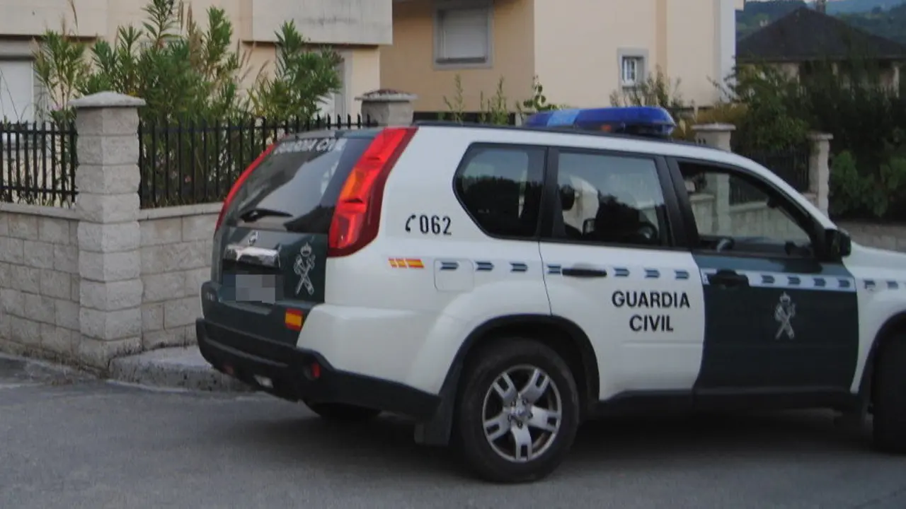 El coche de la Guardia Civil ante la casa que fue asaltada en Sarria. PORTO