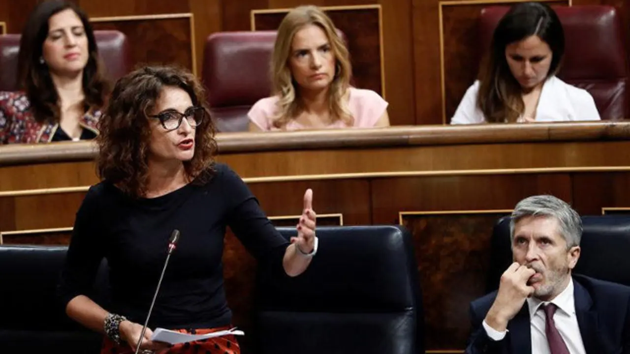 La ministra de Hacienda, María Jesús Montero,durante su intervención en la sesión de control al Gobierno de este jueves. A la derecha, el de Interior, Fernando Grande-Marlaska. MARISCAL (EFE)