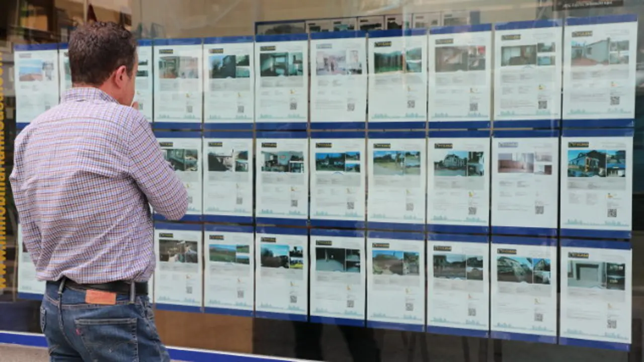 Un hombre mira el escaparate de una inmobiliaria. DP