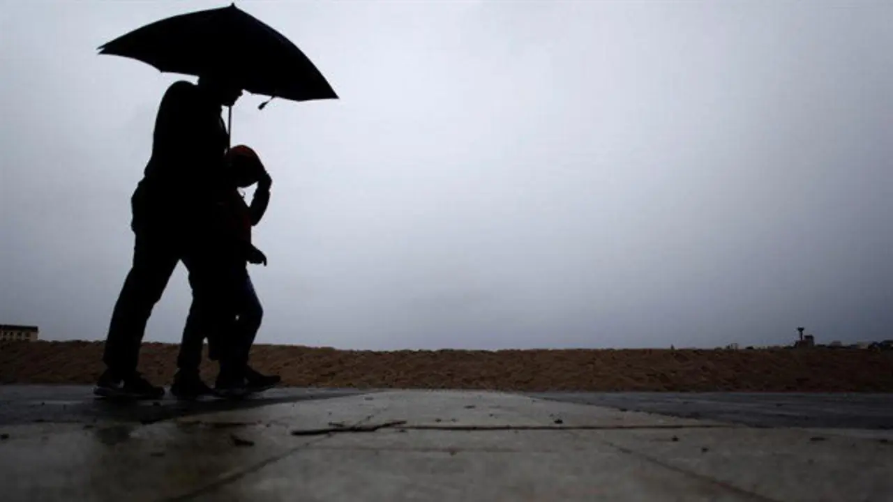 Dos hombres pasean bajo la lluvia en A Coruña. CABALAR