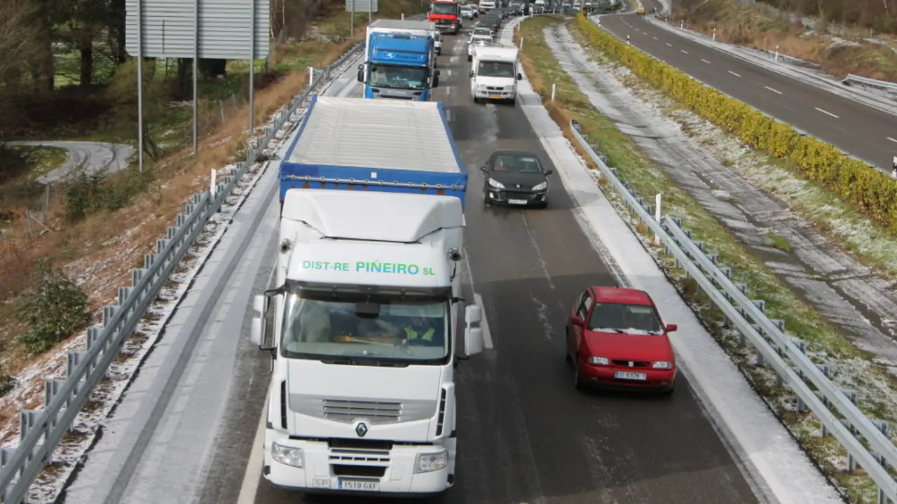 Coches y camiones en una autovía. EP