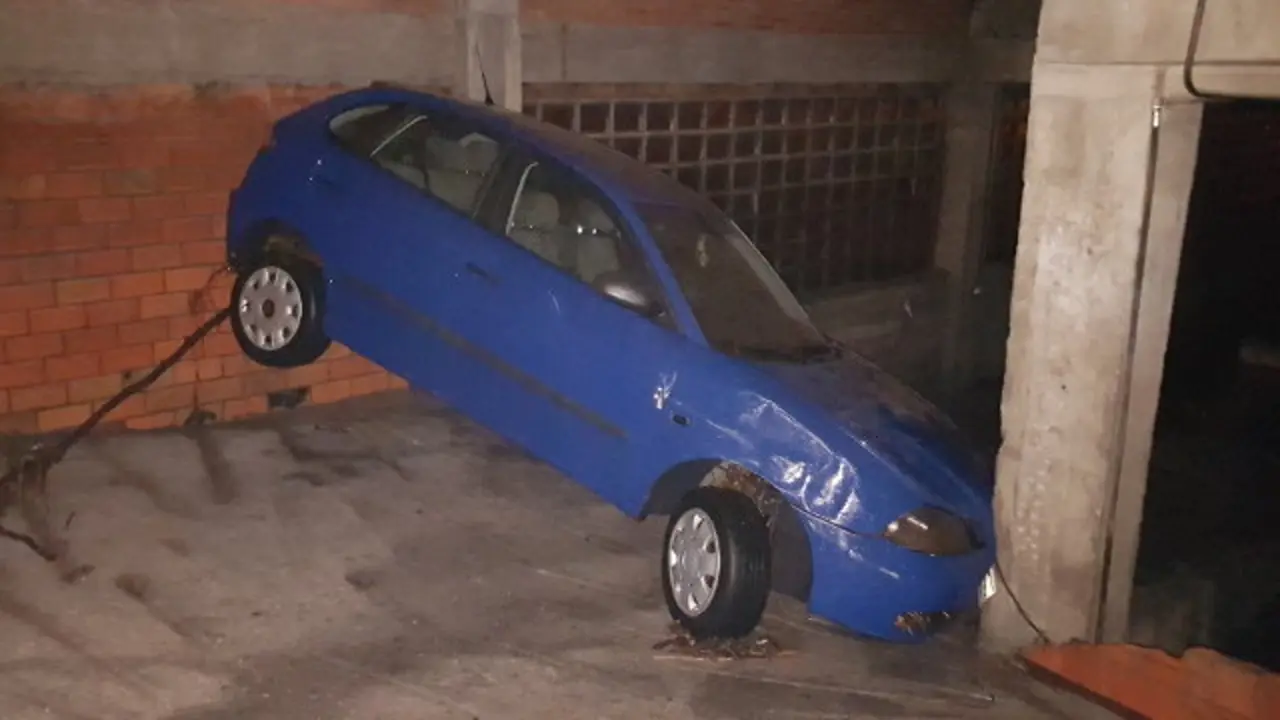 Un coche arrastrado hast un garaje. ANTÍA