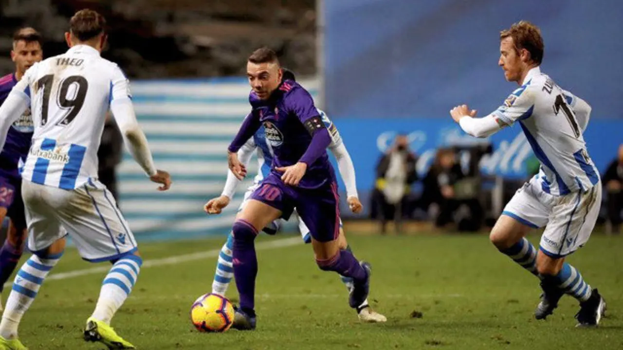 Iago Aspas conduce el balón ante los jugadores de la Real. JAVIER ETXEZARRETA (EFE)