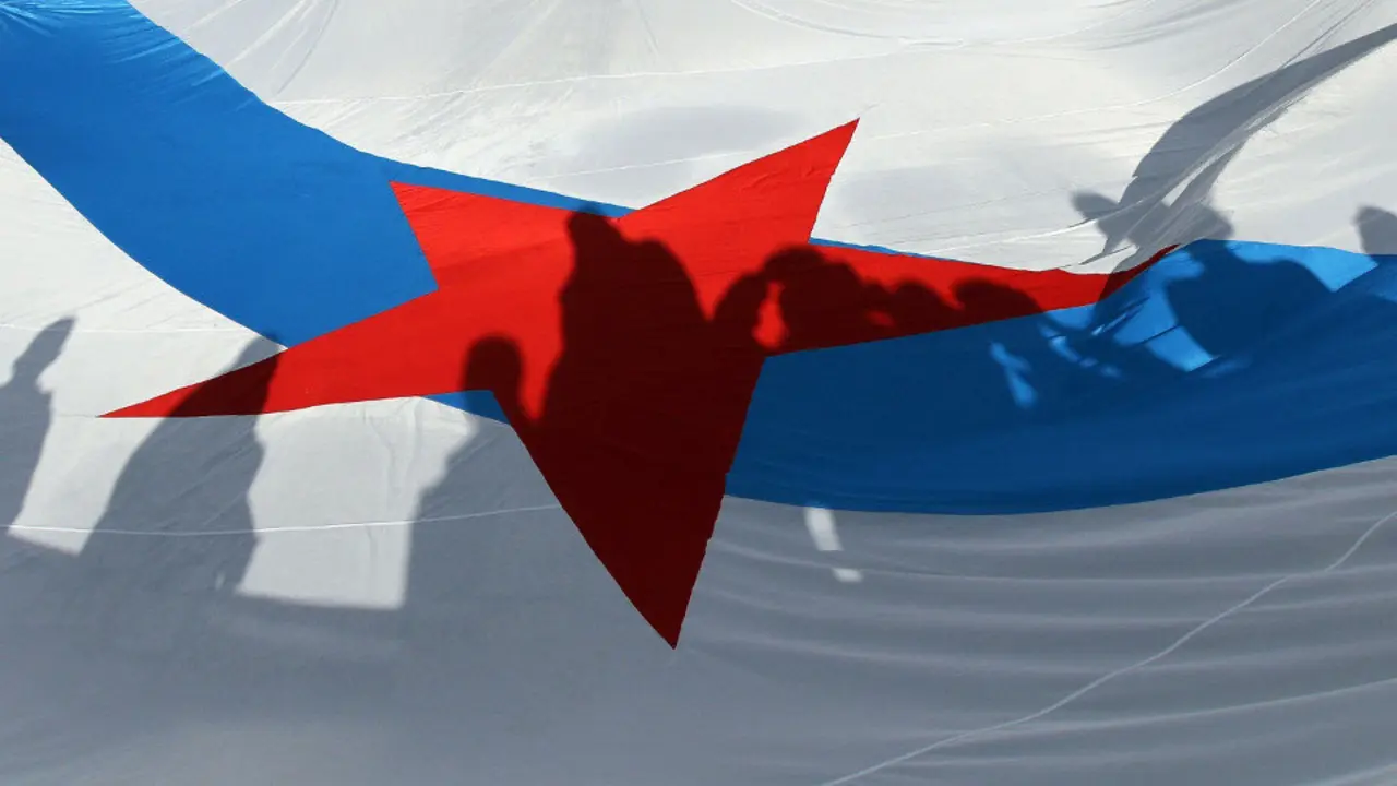 Sombras de manifestantes sobre una bandera nacionalista, este jueves, en la plaza del Obradoiro. LAVANDEIRA JR. (EFE)