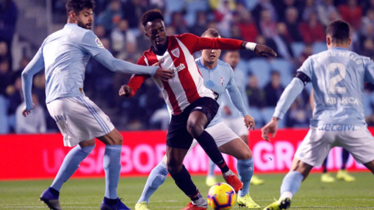 El delantero del Athletic de Bilbao Iñaki Williams pelea un balón con el defensa mexicano del Celta, Néstor Araujo. SALVADOR SAS (EFE)