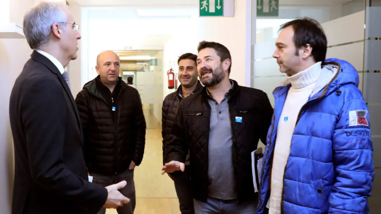 El conselleiro  Francisco Conde conversa en San Caetano, con representantes de comité de empresa de Alcoa. XOÁN REY (Efe)