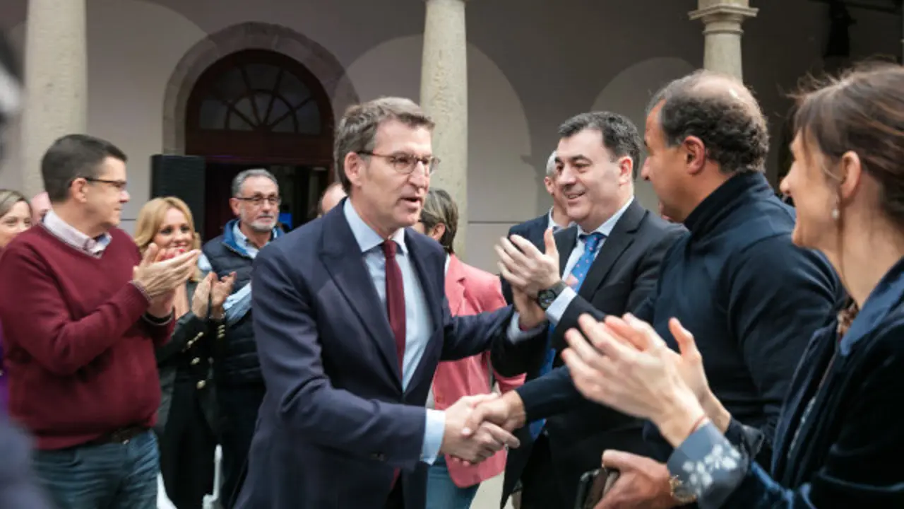 Feijóo estrecha la mano de Javier Guerra. LUIS POLO