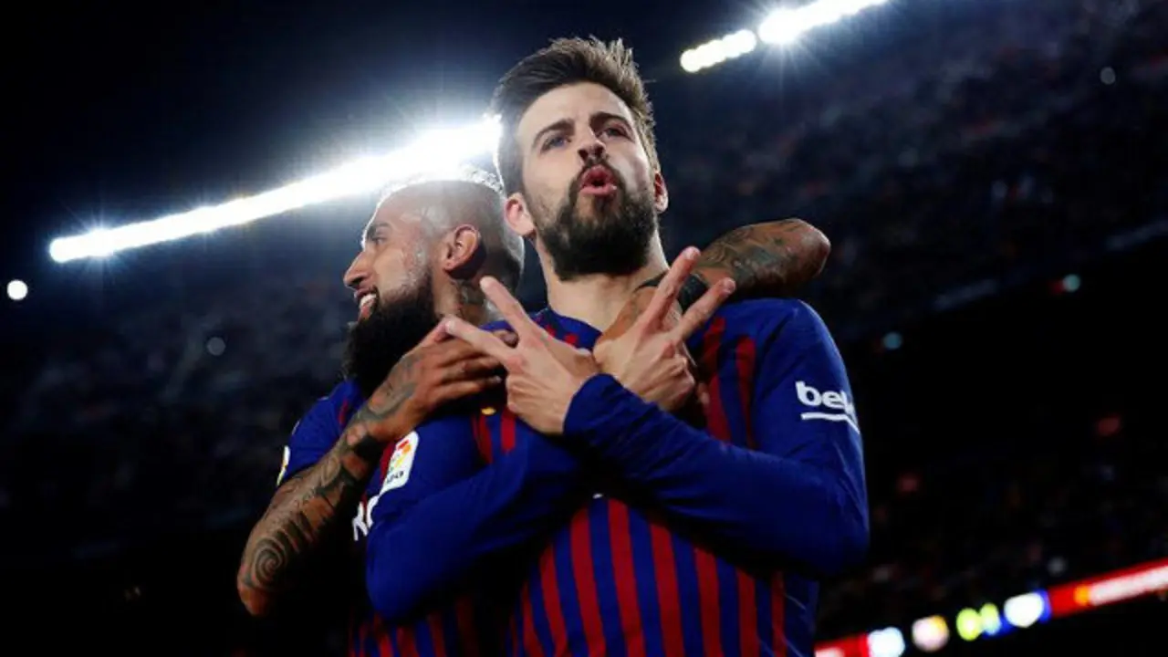 El defensa del FC Barcelona Gerard Piqué celebra su gol ante el Rayo Vallecano con el chileno Arturo Vidal. ALEJANDRO GARCÍA (EFE)