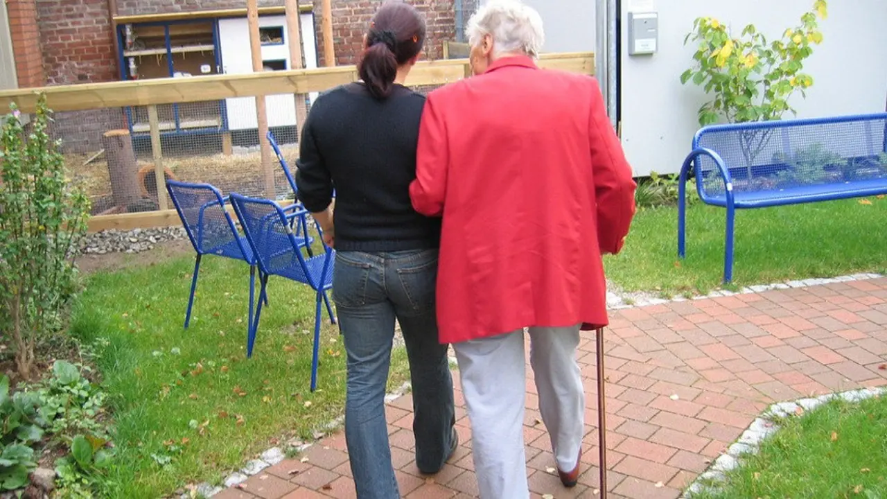 Una mujer cuida a una persona dependiente.EP