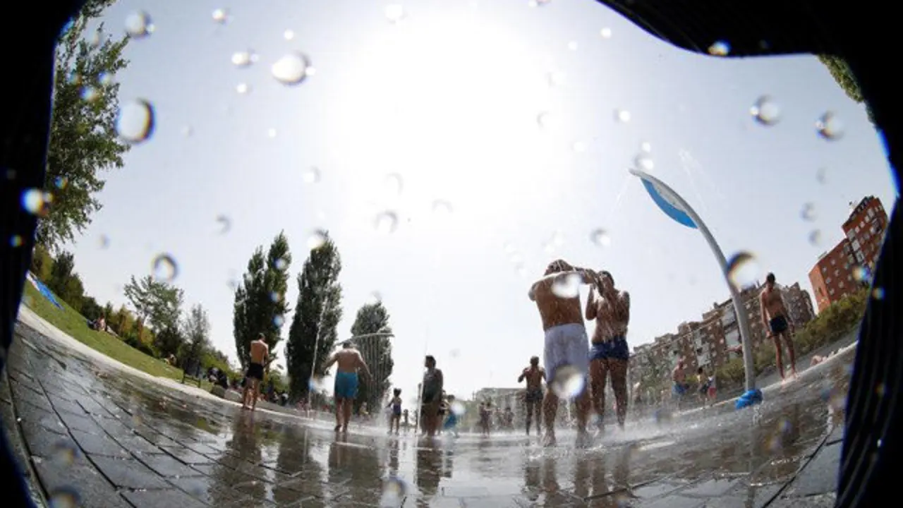Varias personas se refrescan en una fuente. ZIPI