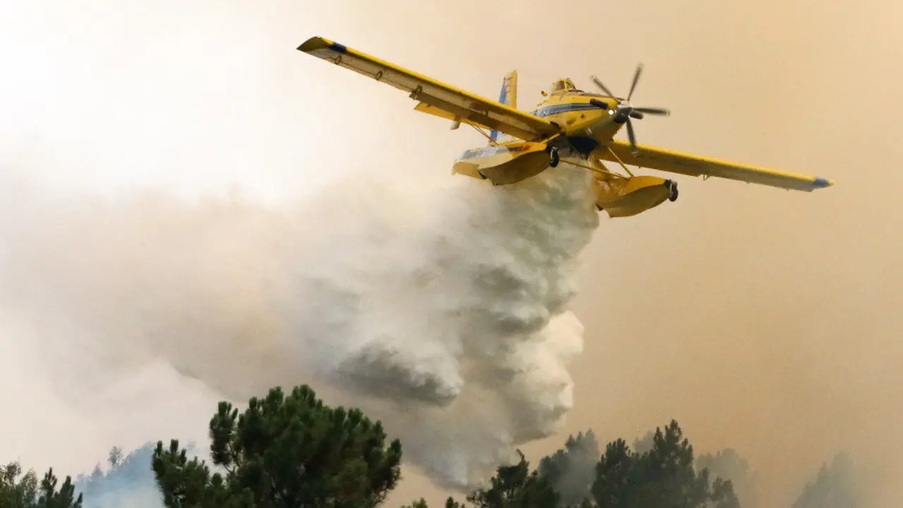 Un avión arroja agua sobre uno de los incendios que afectan a Mação. ANTONIO JOSÉ (EFE)