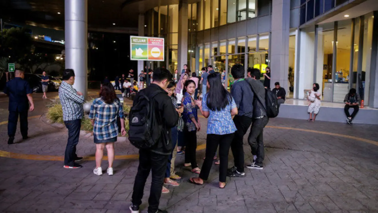 Varias personas esperan en el exterior de un edificio en Indonesia tras el terremoto. EFE