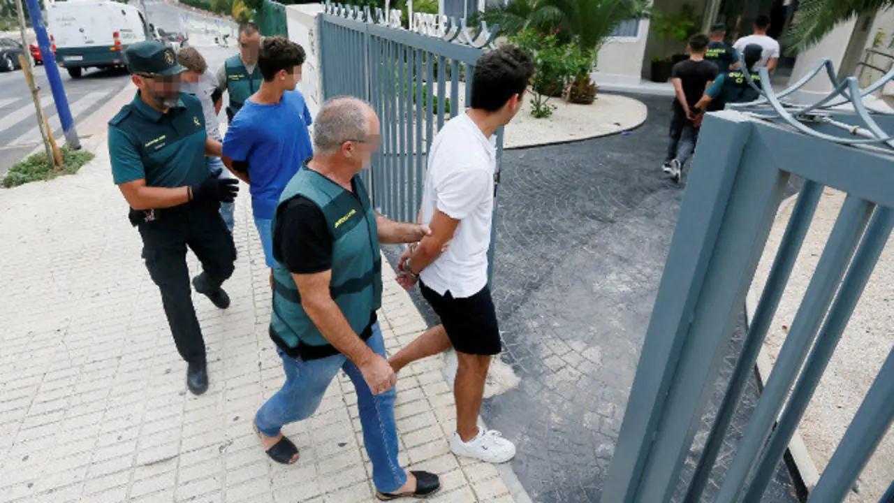 Los jóvenes detenidos entran custodiados en el edificio de Benidorm en el que ocurrieron los hechos. EFE