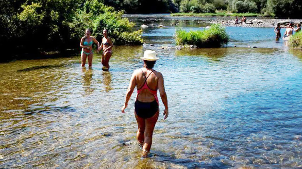 Bañistas en las termas de O Muiño da Veiga y la zona fluvial del río Miño. BRAIS LORENZO (EFE)