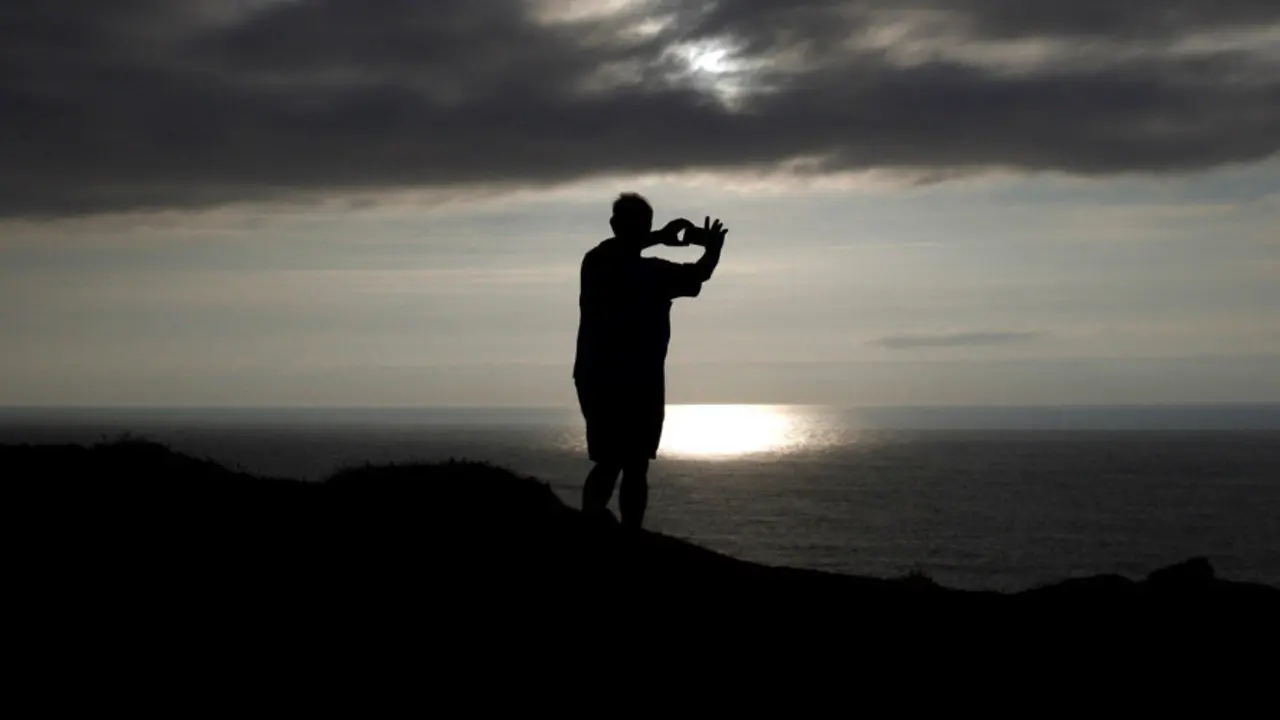 Un hombre toma una fotografía desde cabo Touriñán, en Muxía.  CABALAR (EFE)