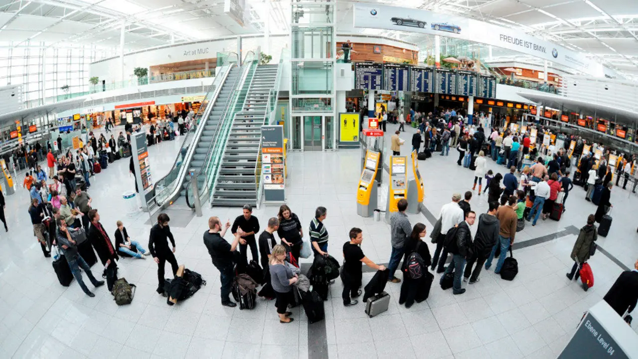 Pasajeros hacen cola delante de un mostrador de información en el aeropuerto de Múnich. TOBIAS HASE (EFE)
